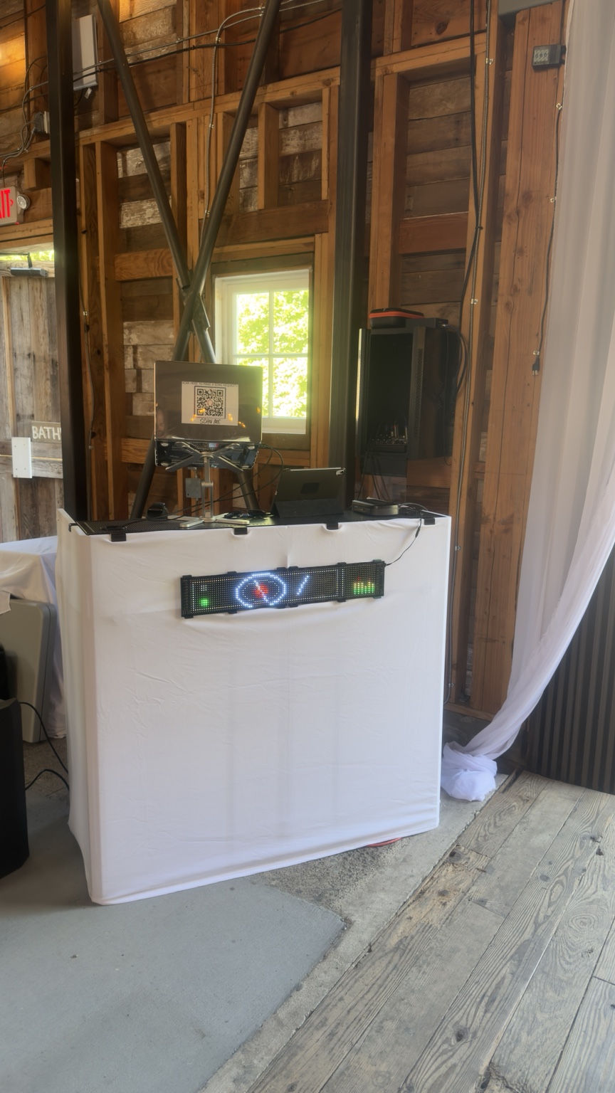 White DJ booth with sound equipment and lighting inside the barn