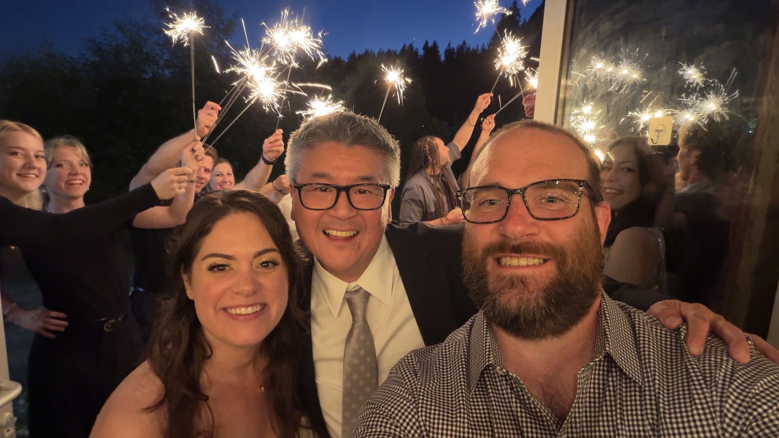 Wedding celebration with a smiling group and guests holding sparklers